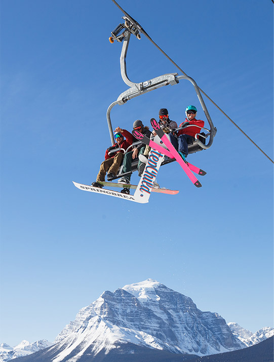 Four boys with snowboards on the gondola at Lake Louise Ski Resort.