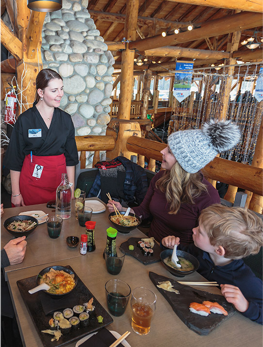 Family of four dining at a restaurant at Lake Louise ski resort.